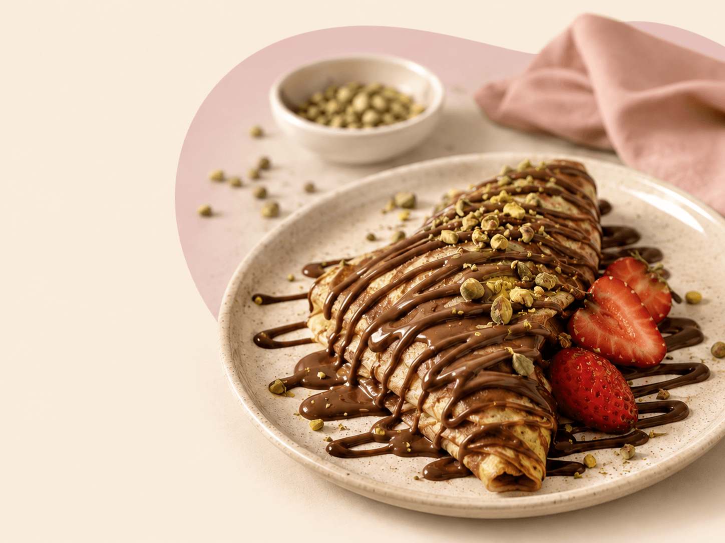 Pistachio chocolate crepe on a speckled plate